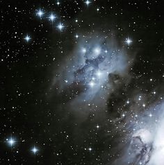 the large star cluster is surrounded by stars in the night sky, as well as bright blue and white lights