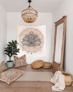 a room with a wooden floor, mirror and rug on the wall next to a potted plant