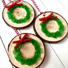 three pieces of wood are decorated with green wreaths and red ribbons on the ends