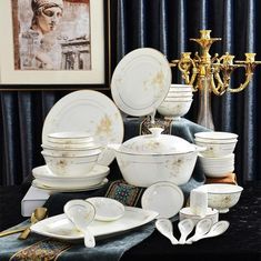 an assortment of white and gold dinnerware on display