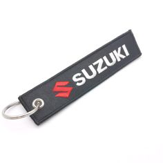 a keychain with the word suzuki on it and a metal hook attached to it