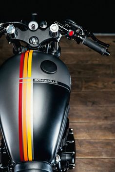 the front end of a black motorcycle with red, yellow and orange stripes on it