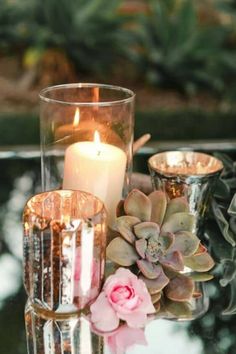 candles and succulents sit on a glass table