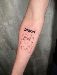 a person with a tattoo on their arm that reads blond and is holding a cell phone