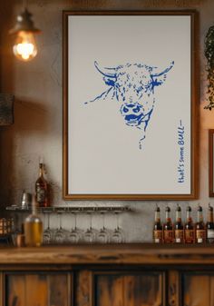 a cow is shown on the wall above a bar with bottles and glasses in front of it