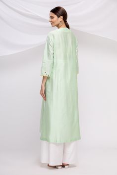 Mint green straight long kurta with all-over line thread work in jaal pattern. Comes with wide-legged white pants and scallop border floral embroidered dupatta.
Components: 3
Fabric: Silk Chanderi
Neckline: V Neck
Sleeve Length: Three Quarter
Color: Green
Embroidered
Scallop border
Elastic waistband
Side slits - Aza Fashions V Neck Kurta, Kurta Set For Women, Luxury Sale, Straight Kurta, Thread Work, Kurta Set, Green Silk, Cut Work, White Pants