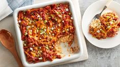 a casserole dish with meat and vegetables in it next to a wooden spoon