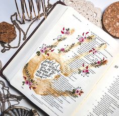 an open book sitting on top of a table next to some cookies and other items