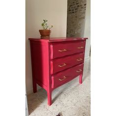 a red dresser with gold handles in a room