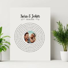 a white poster with the words sara and john on it next to potted plants