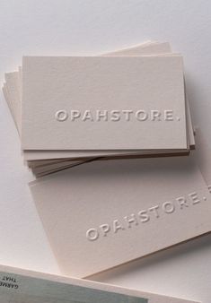 three white business cards with the words opahstore on them sitting next to each other