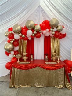 a red and gold table topped with balloons