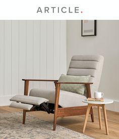 a chair with a footstool sitting on top of it in front of a rug