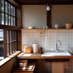 a kitchen with a sink, window and wooden counter top in front of the windows