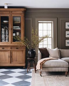 a living room filled with furniture and a checkered rug on the floor next to a window