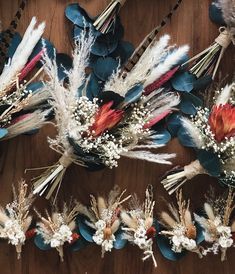 dried flowers and feathers are arranged on a table