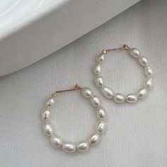 We think every woman should own some pearls. There's nothing like the beauty and luster of a pearl. They're a staple in every jewelry box. That being said we love our pearls to be different, unique, and unexpected. Stun in our Baby Pearl Hoop Earrings. Handmade ear wires in sterling silver or 14kt gold fill with genuine freshwater rice pearls. 1 inch diameter hoop. Handmade Everyday Pearl Earrings, Classic Hoop Earrings With Pearl Chain For Gift, Chic Hoop Earrings With Pearl Charm For Gift, Pearl Teardrop Hoop Earrings As Gift, Teardrop Pearl Hoop Earrings For Gifts, Pearl White Hoop Earrings With Pearl Chain For Gift, Hoop Pearl Pendant Jewelry For Wedding, Elegant Hoop Earrings With Pearl Charm For Gift, Everyday Pearl White Pearl Earrings