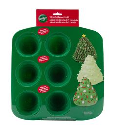 a green tray filled with cupcakes covered in frosting and christmas tree decorations