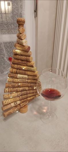 a wine glass sitting next to a cork christmas tree