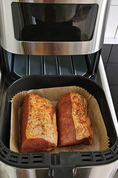 two loafs of bread sitting in a pan on top of an appliance