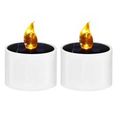 two white candle holders with gold colored candles in them on top of black and white bases