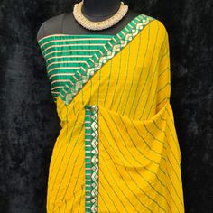 Product Detail - yellow colored casual wear saree is made from moss georgette fabric which is highlighted with beautiful stripes printed work with lace border as shown. Comes along unstitched heavy gota blouse piece which you can customise as per your design/style. Occasion - You can wear this saree for casual, outings, social meets and other homely events. Style it up - Look glamorous in this traditional saree by (HELUM FAB) Pair this saree with beautiful clutch to complete the look!! Measureme Yellow Georgette Pre-draped Saree With Pallu, Yellow Saree With Unstitched Blouse For Navratri, Navratri Yellow Saree With Unstitched Blouse, Yellow Unstitched Georgette Blouse Piece, Yellow Semi-stitched Blouse Piece With Printed Border, Semi-stitched Yellow Blouse Piece With Printed Border, Yellow Bandhani Print Georgette Dupatta, Semi-stitched Yellow Blouse Piece With Traditional Drape, Semi-stitched Yellow Blouse Piece In Traditional Drape