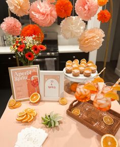 a table topped with orange slices and cupcakes