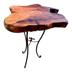 a wooden table with metal legs and a flower design on the top that is shaped like a tree trunk