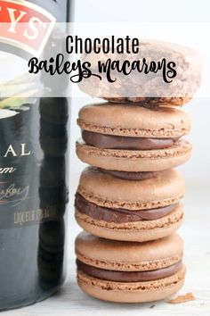 chocolate bailey's macarons stacked on top of each other next to a bottle of wine