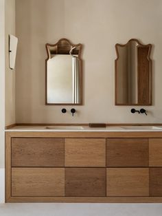 a bathroom with two sinks and mirrors on the wall