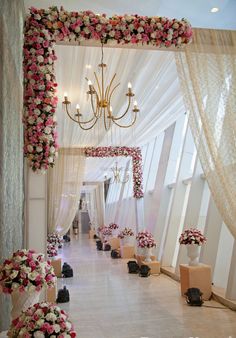 an aisle decorated with flowers and chandelier