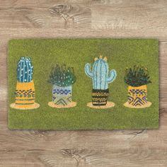 a door mat with three cactus plants on it, one is green and the other is yellow