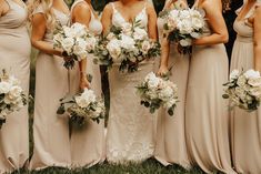 a group of women standing next to each other with bouquets in their hands and holding flowers