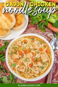 a bowl of cajun chicken noodle soup on a table with bread and vegetables