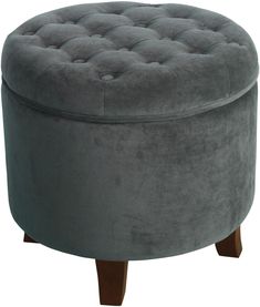 a round ottoman with wooden legs and grey velvet upholstered cushion on the top