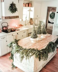 a kitchen with white cabinets and wooden counter tops covered in greenery, surrounded by potted plants