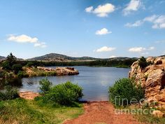 a body of water surrounded by rocks and grass