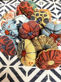 a bunch of fabric flowers sitting on top of a black and white tablecloth covered floor