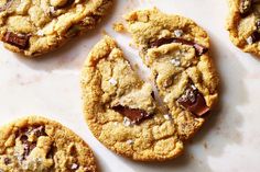 several chocolate chip cookies on a white surface