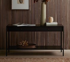 a table with a vase and some books on it