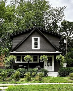 a black and white house with trees in the background