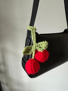 a crocheted strawberries bag hanging from a hook