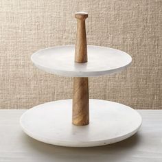 two tiered white cake stand with wooden handle