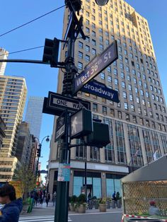 a street sign on the corner of broadway and 42nd st in front of a large building