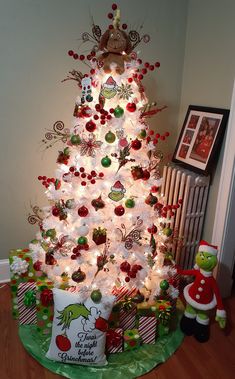 a white christmas tree with red and green ornaments