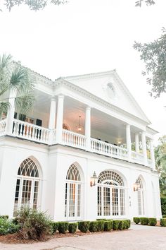 a large white house with lots of windows and balconies