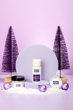 the products are on display in front of purple christmas trees and snow - covered ground