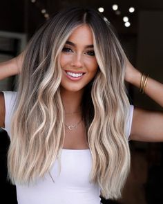 Beautiful bronde hair color on long wavy hair. Looking for some fabulous hair inspo? This collection of the 21 most gorgeous hair color ideas will help you find the perfect shade. From stunning ombres to trendy vibrant shades, we've got you covered. Say goodbye to boring hair and make a bold statement with a fresh new hair color. Sand Blonde Hair Balayage, Dimensional Blonde With Dark Roots, Blended Roots Blonde, Champagne Blond, Interesting Hairstyles, Hair Fancy, Bronde Hair