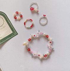 three pieces of jewelry sitting on top of a table next to an envelope and brochure