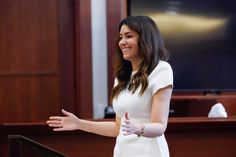 a woman standing in front of a podium giving a speech to someone behind the podium